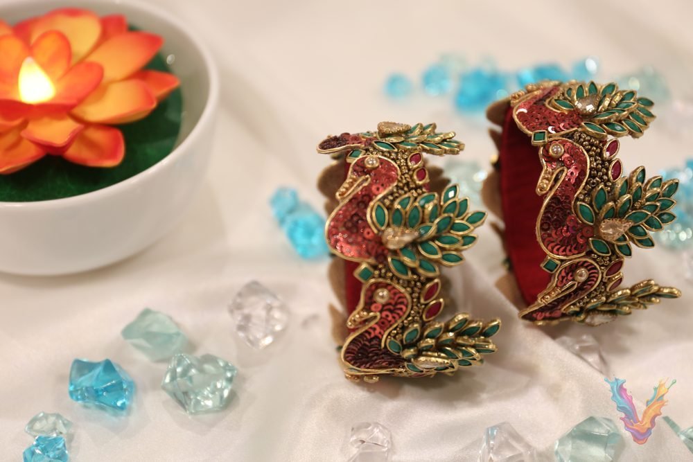 Colorful peacock silk thread bangles displayed on a wooden stand