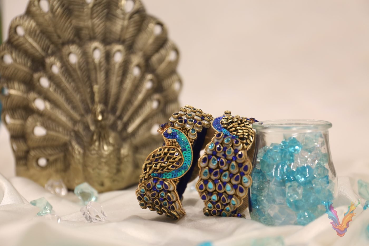 Mixed peacock bangles and gold bangles on a dark stand