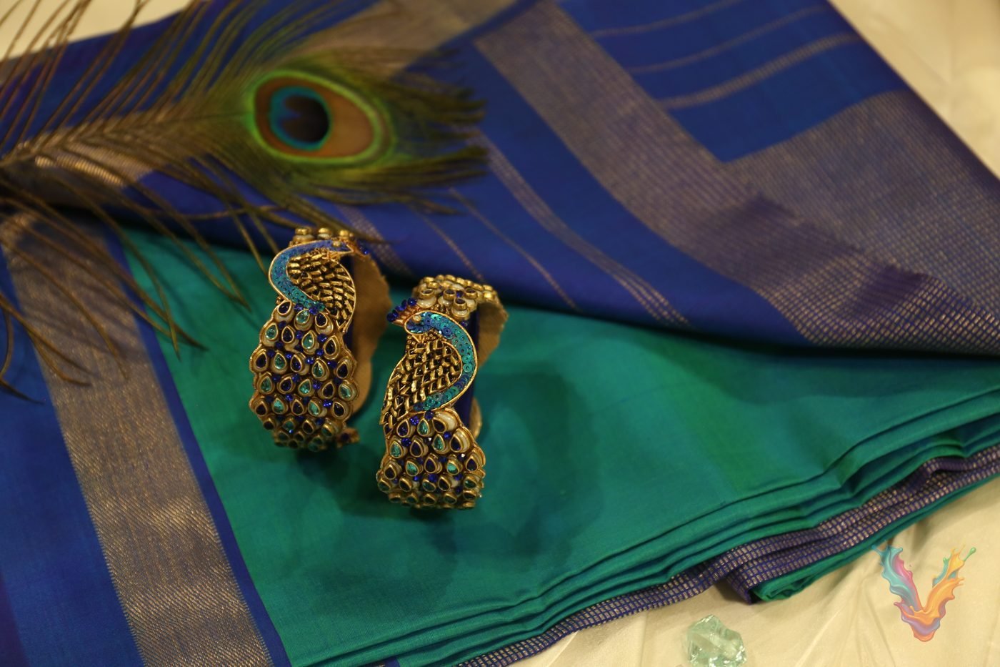 Peacock bangles on a blue and green silk saree with a peacock feather